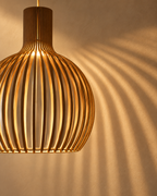 Skandinavisk Pendel Lampe i Træ – Lameldesign til Spisebord – vist i et minimalistisk interiør